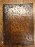 Front cover binding of volume one with pencil for scale.