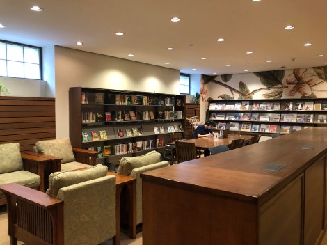 Image of popular reading room with book shelves with books, comfortable seating, and decorative wall art